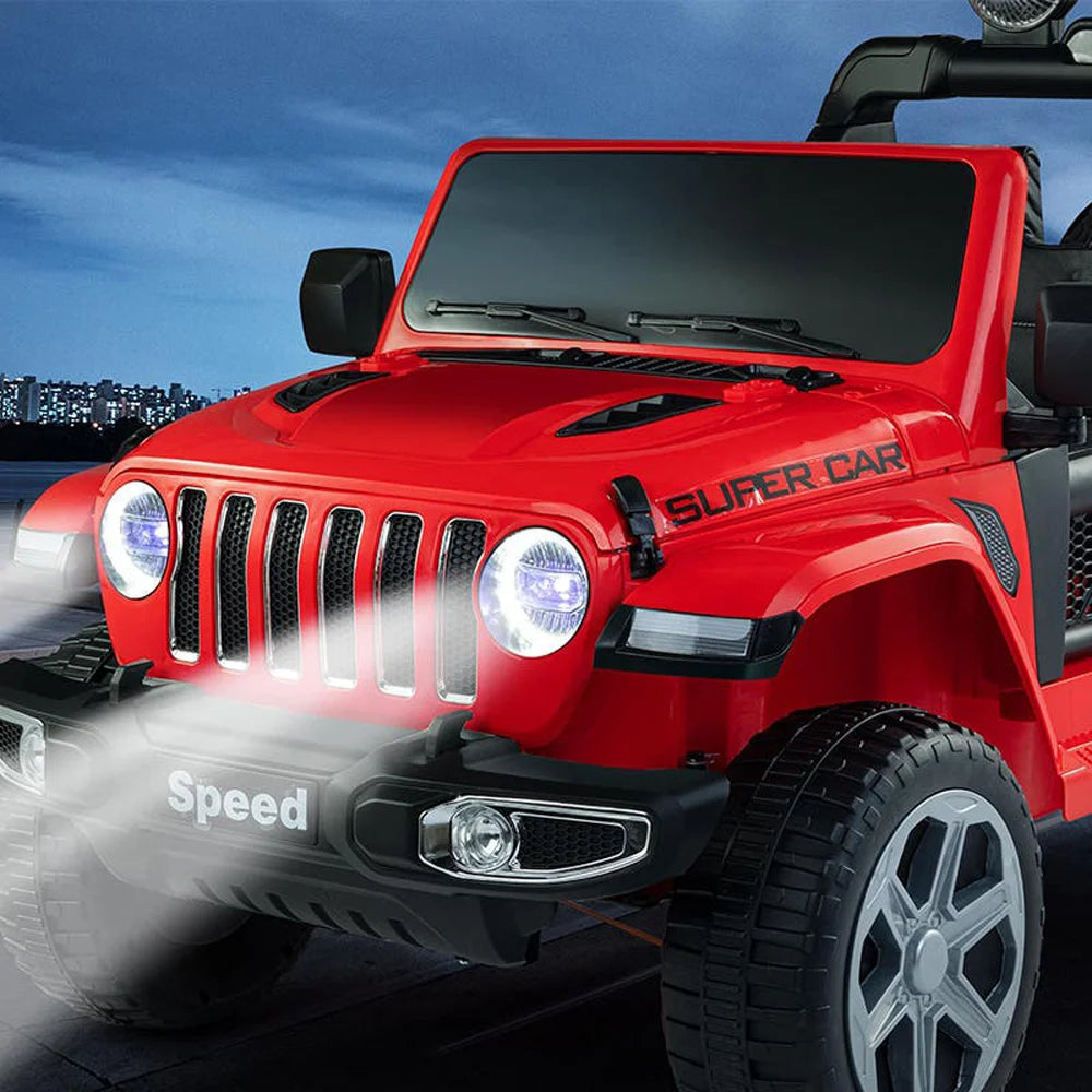 Close-up of a red 12V 4WD Jeep Wrangler Rubicon kids ride-on toy with headlights on and rugged tires.