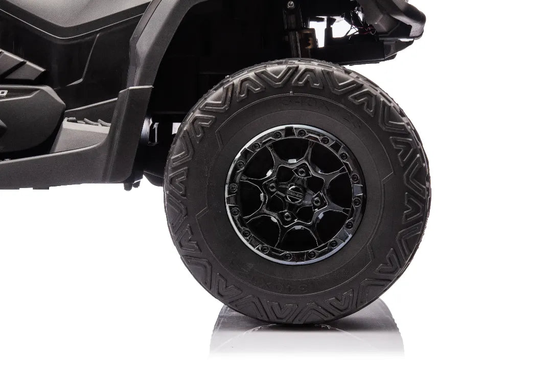 Close-up of black alloy wheel and durable off-road tire on 24V licensed Can-Am Outlander 2-seater 4x4 ATV quad bike