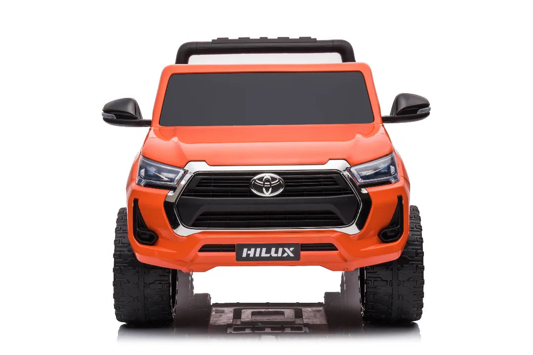 Front view of orange 24V licensed Toyota Hilux SR5 2-seater kids ride-on ute with black grille and mirrors