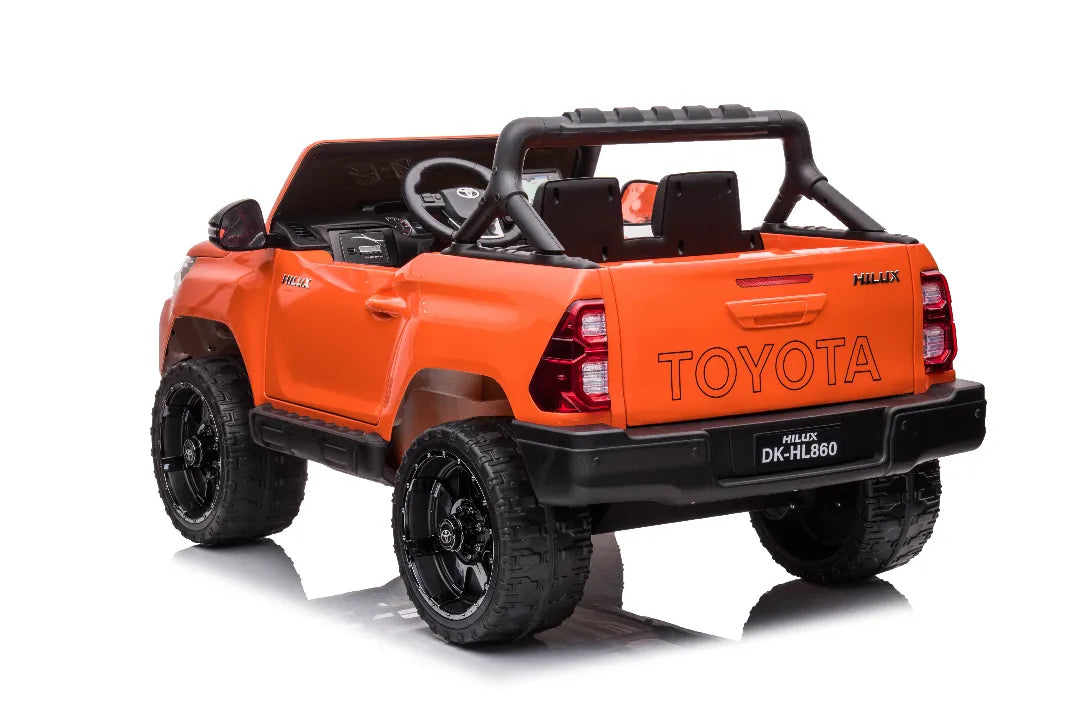 Rear view of orange 24V licensed Toyota Hilux SR5 4x2 2-seater kids ride-on ute with rugged black wheels
