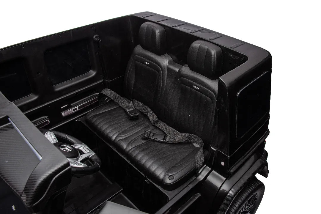 Interior view of black 24V 14Ah licensed Mercedes-AMG G63 kids ride-on car with leather seats and seatbelts