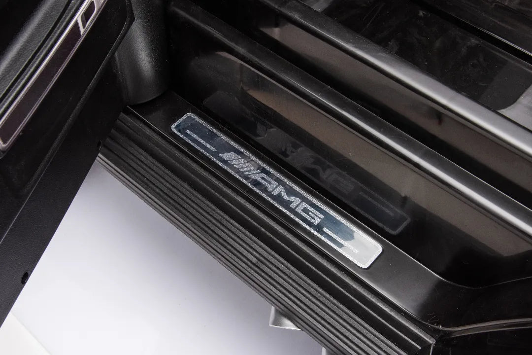 Close-up of black Mercedes-AMG branded door sill on 24V 14Ah licensed G63 kids ride-on car interior step
