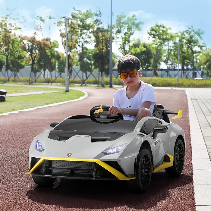 Child driving a grey 24V licensed Lamborghini STO RC ride-on car on a paved outdoor track.