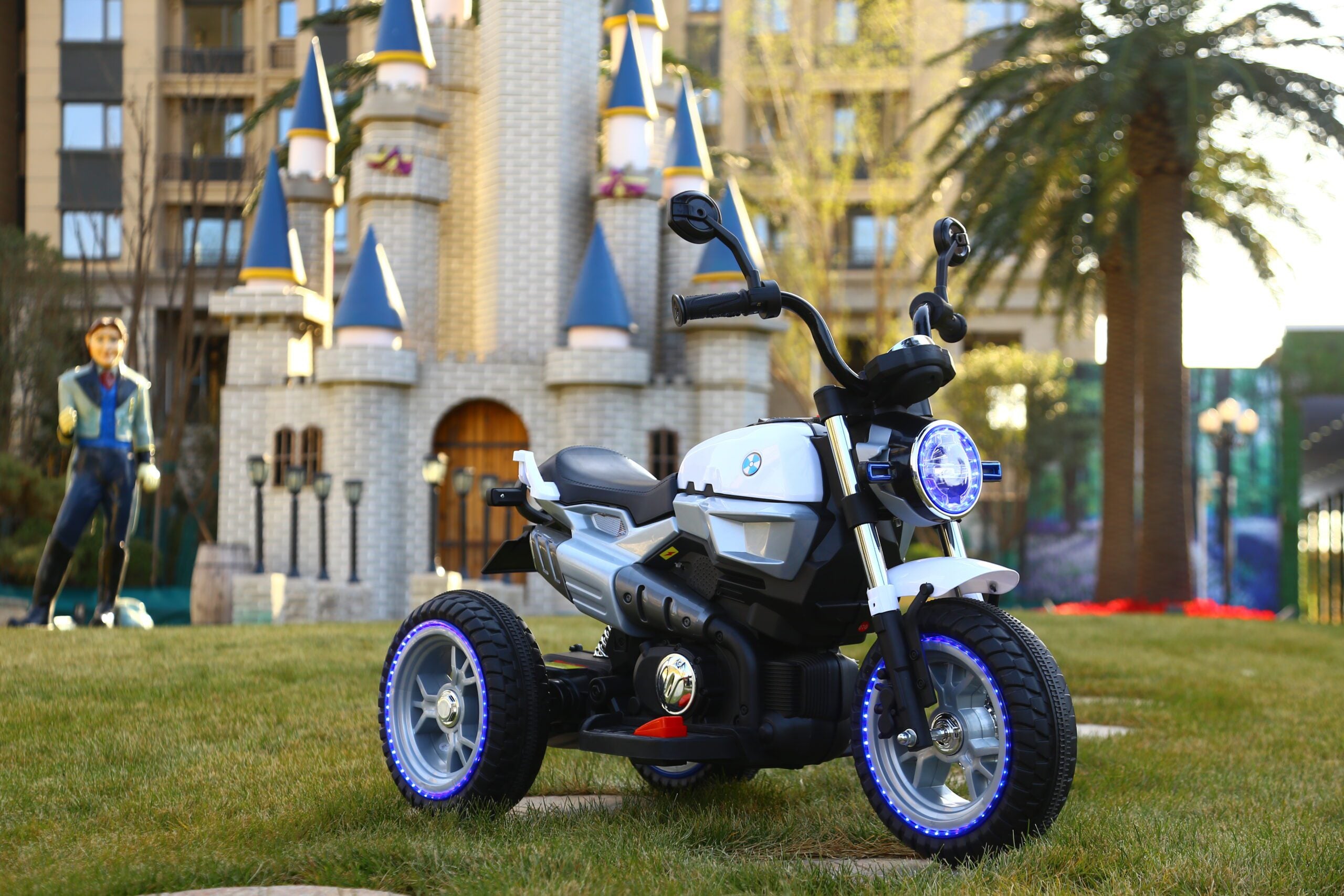 Grey electric motorbike for kids aged 3-7, 12V battery powered ride-on with LED lights and manual controls.
