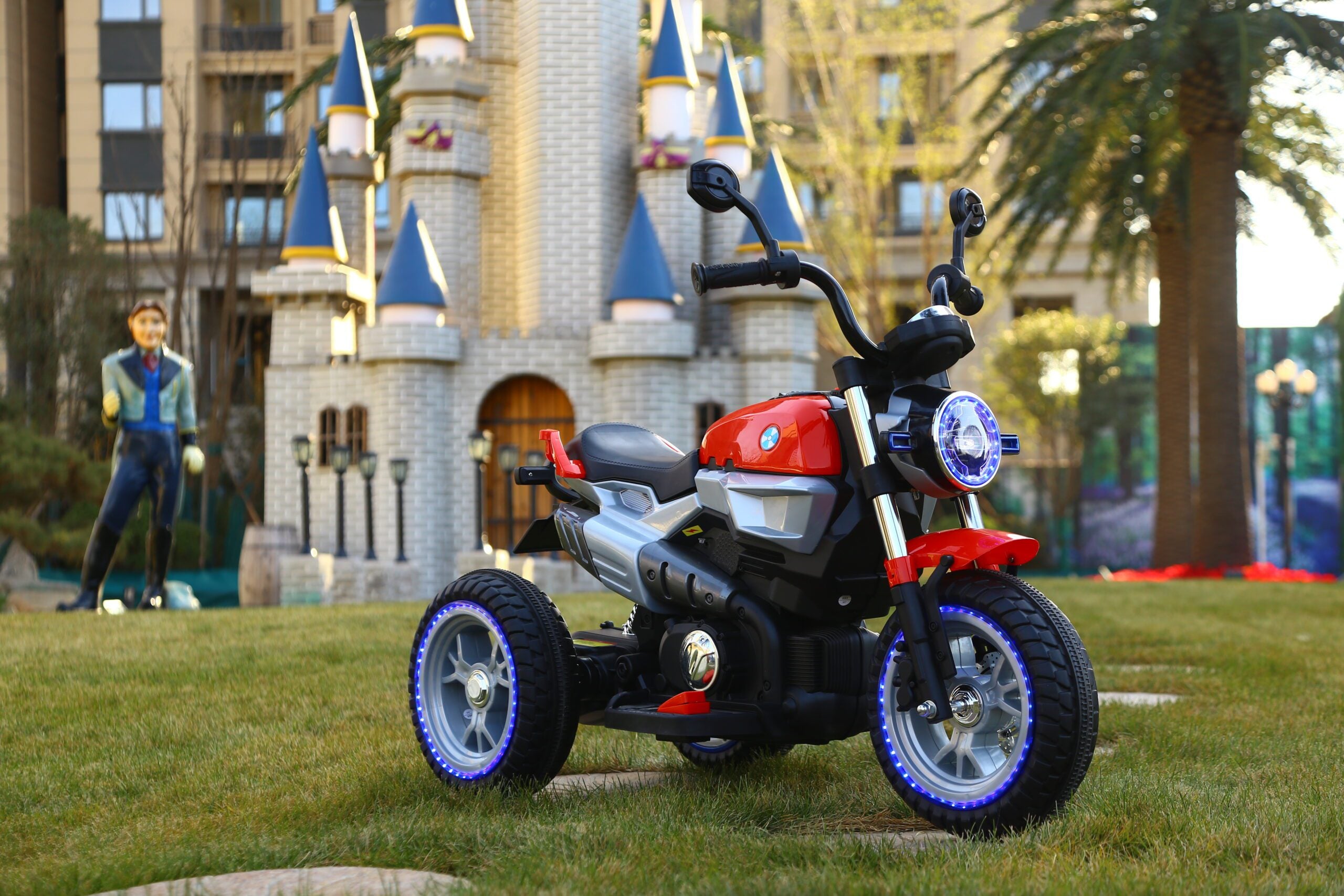 Red and black 12v battery-powered kid’s motorcycle with training wheels, designed for children aged 3 to 7 years.