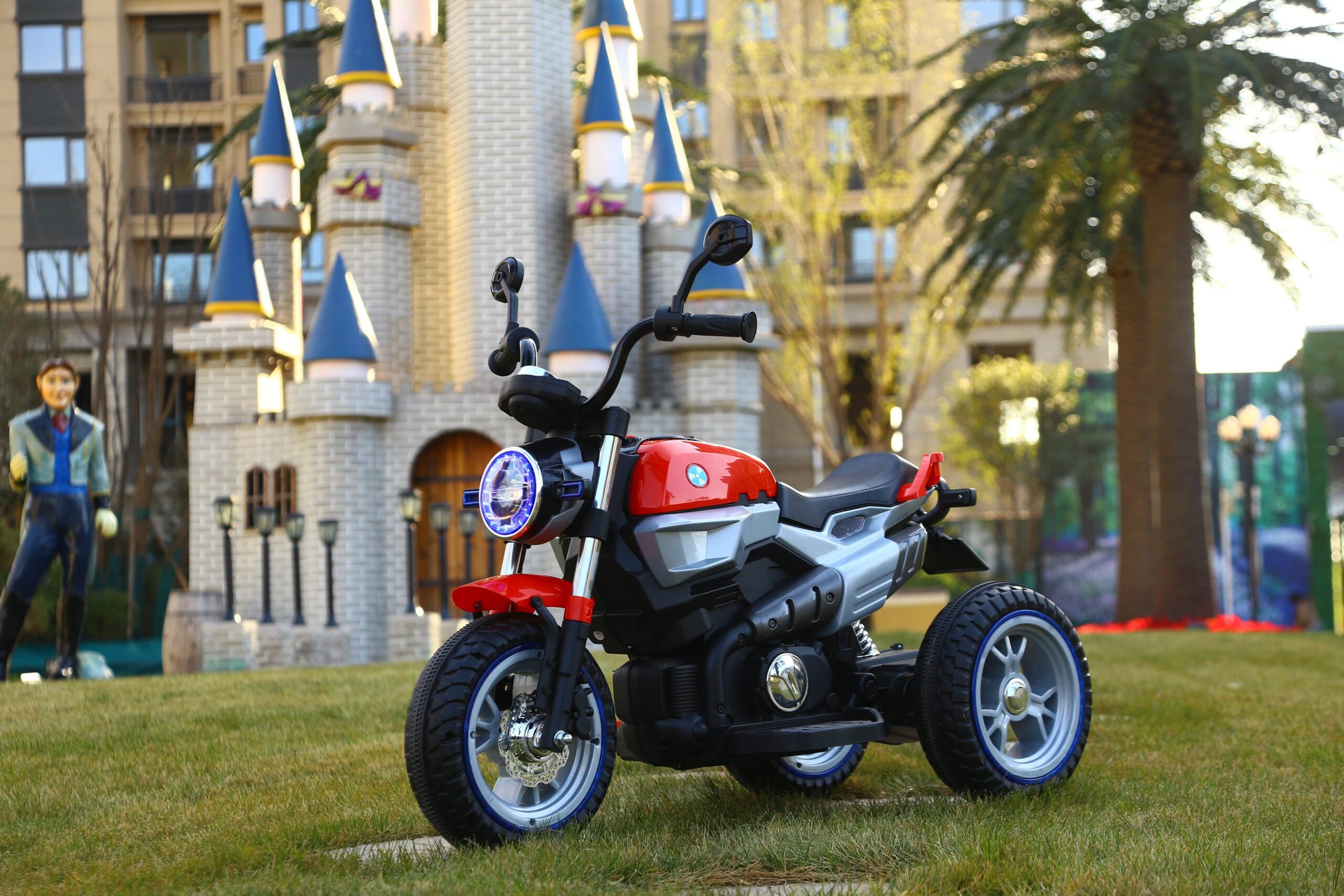 Red and black 12V battery-powered kids motorcycle with three wheels, designed for children aged 3 to 7 years old.
