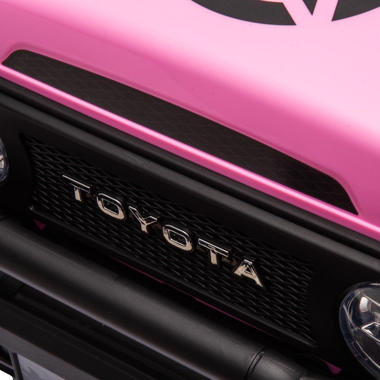 Close-up of the front grill and logo on a pink Toyota FJ Cruiser licensed electric toy car for kids.