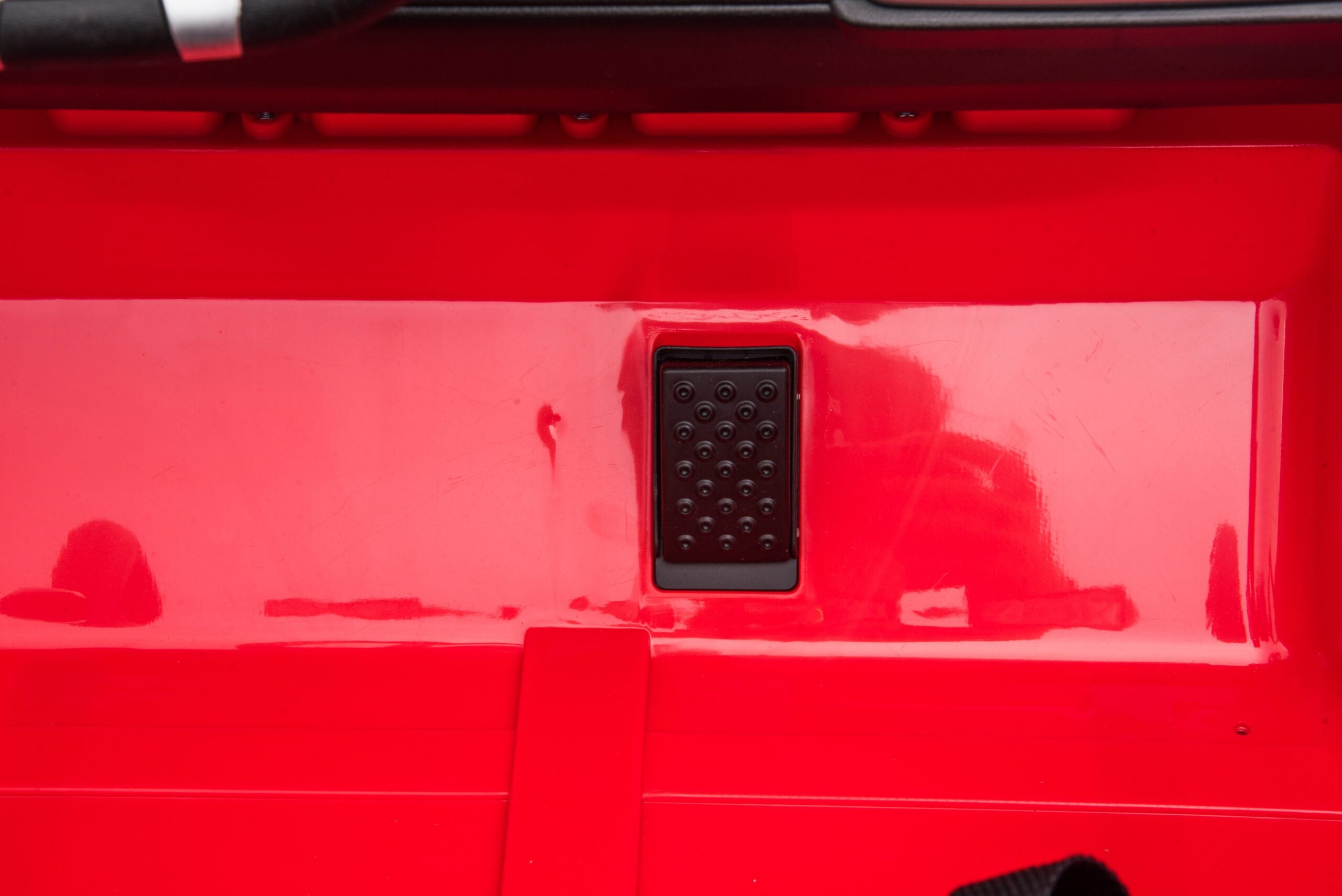 Close-up of the black foot pedal on the red 24V 4WD Toyota FJ-40 kids ride-on electric SUV car interior.