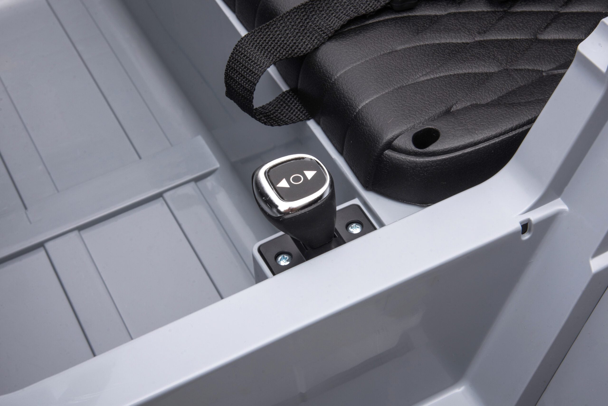 Close-up of black manual control lever and seat inside a 24V 4WD Toyota FJ-40 kids ride-on electric car in black.