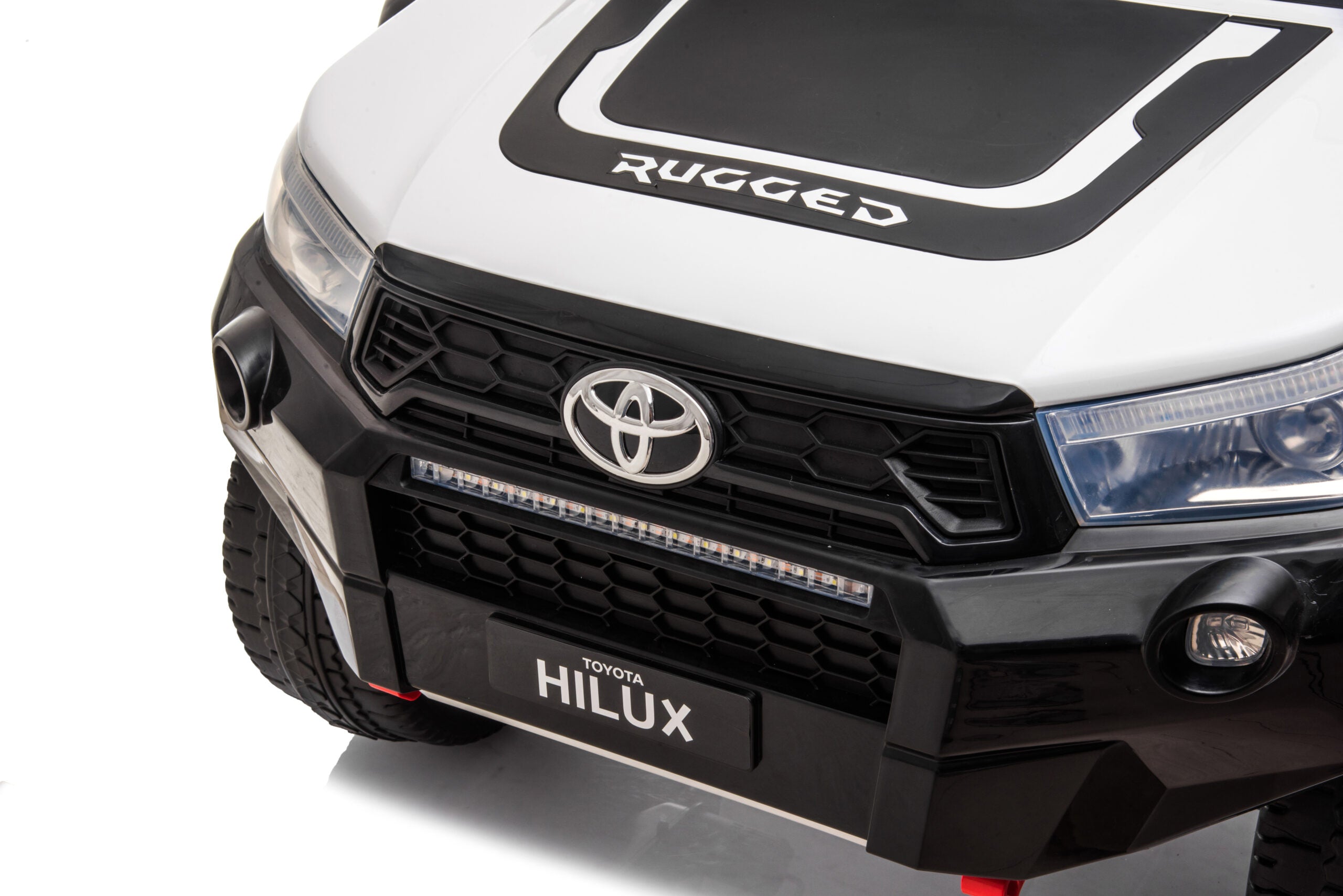 Front view of white 24V Toyota Hilux 4WD ride-on electric car with detailed grill and headlights