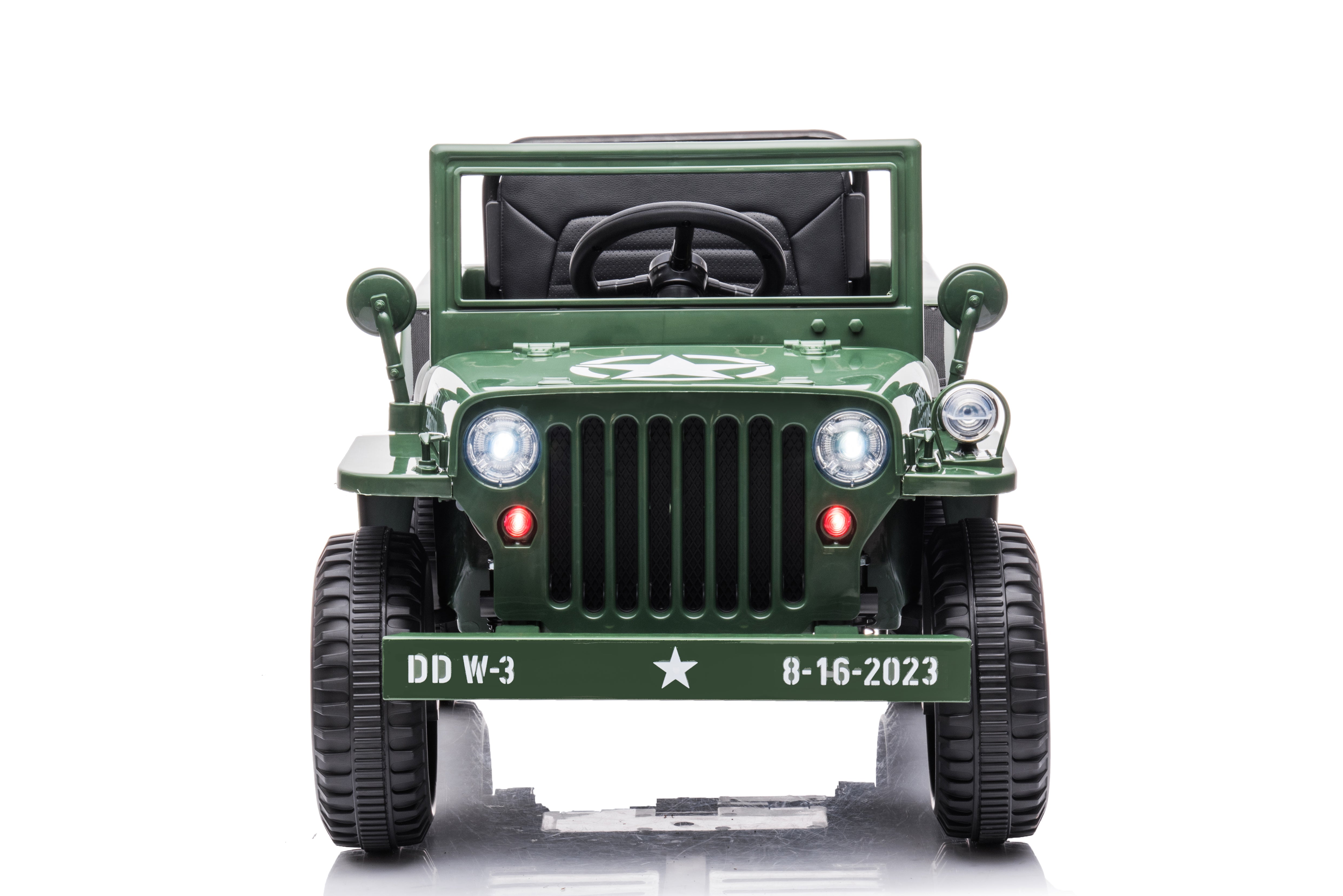 Front view of a green 12V military-style Jeep Willys electric ride-on car for kids with headlights on.