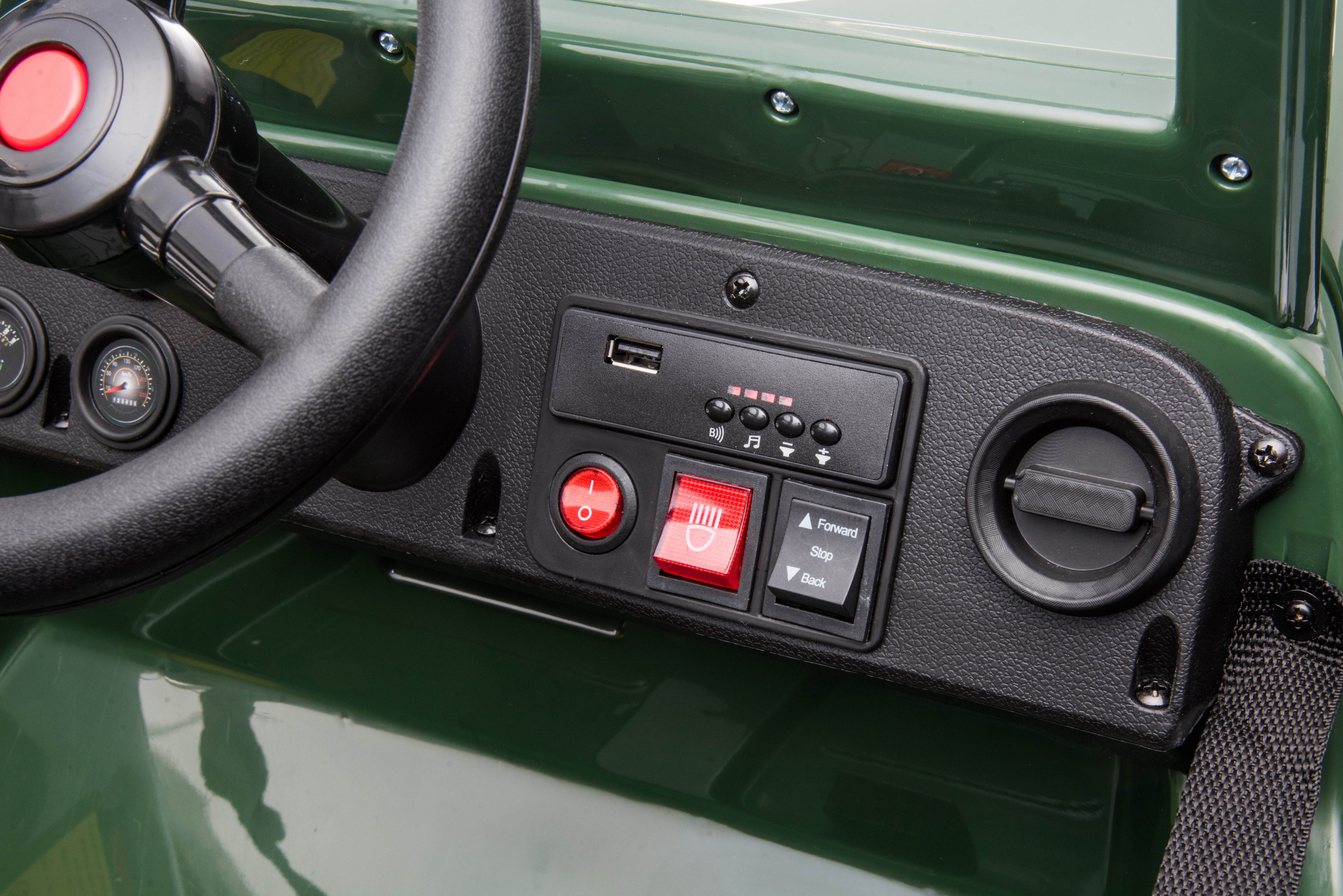 Close-up of the military green ride-on jeep dashboard showing steering wheel, USB port, and control buttons