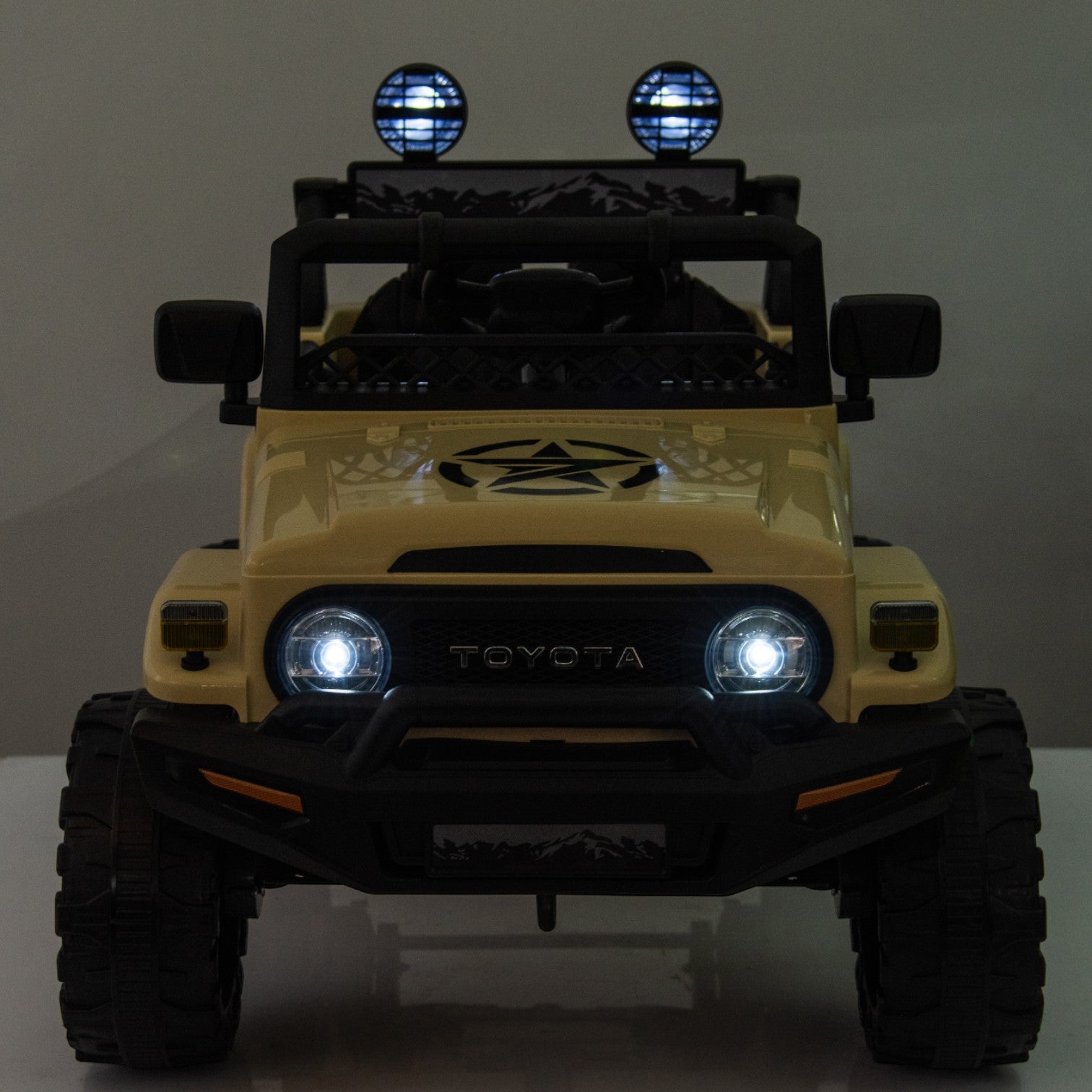 Front view of a yellow Toyota FJ Cruiser licensed 12V electric ride-on toy car with LED headlights and roof spotlights.