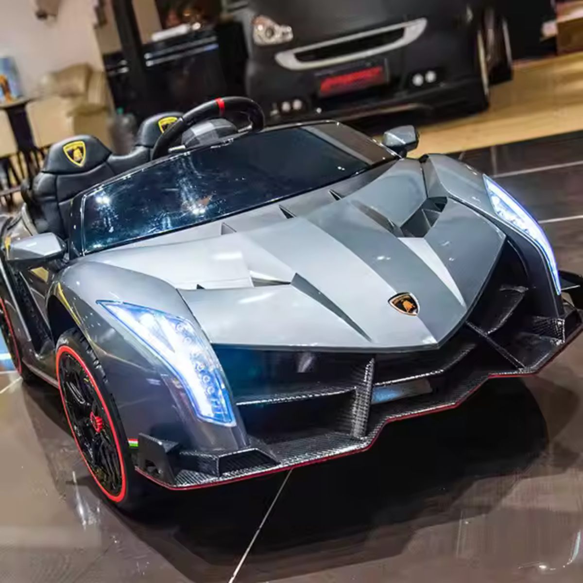 Silver licensed Lamborghini Veneno ride-on car for kids with LED lights and detailed sporty design.