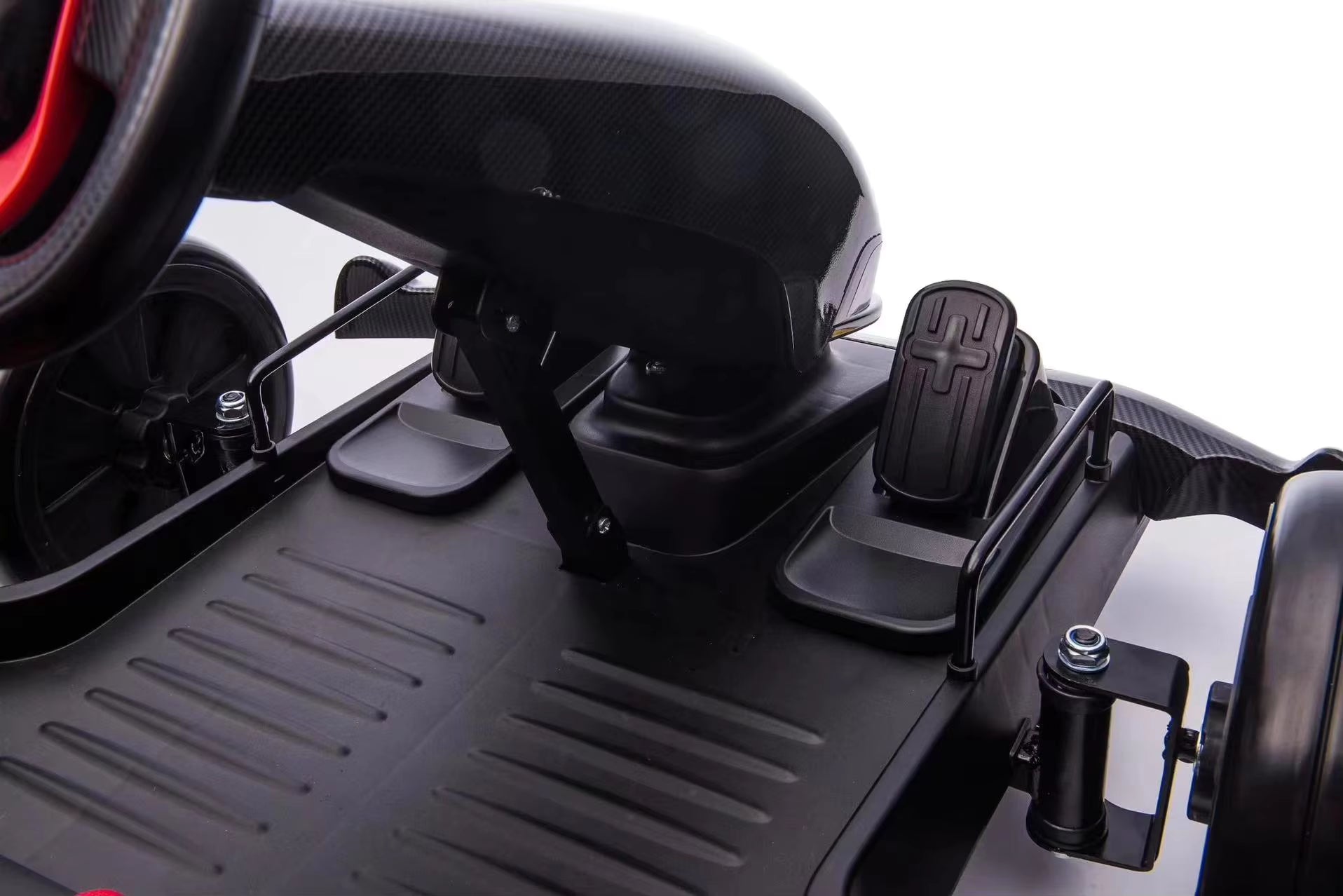 Close-up of black floorboard and accelerator pedal on pink 24V electric kids go-kart with drift function