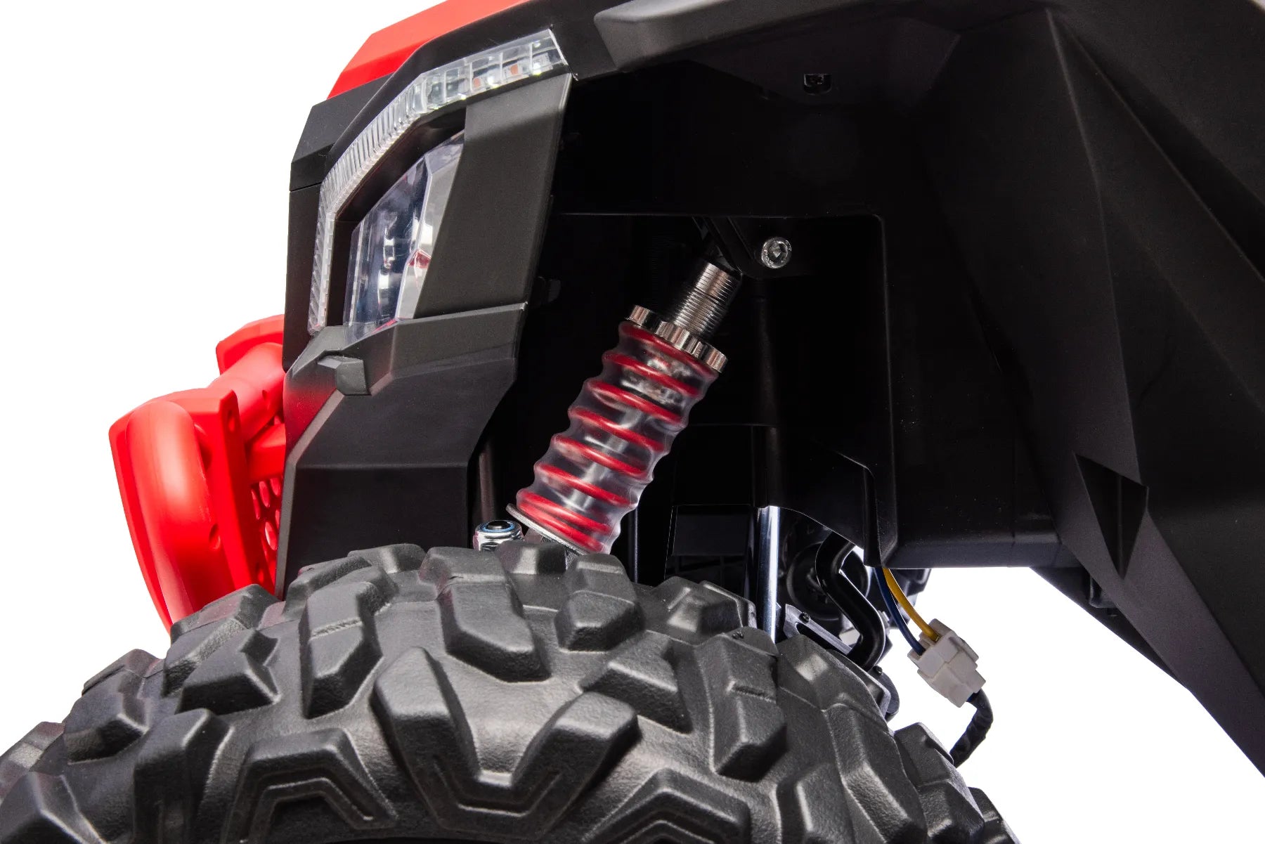 Close-up of red coil suspension and rugged black front tire on King of UTVs ZForce RZR Turbo 24V kids ride-on buggy