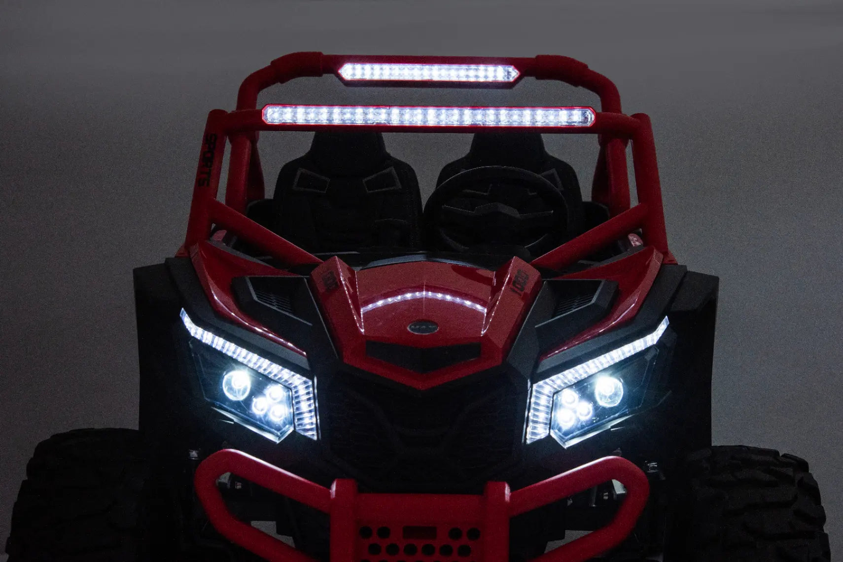 Front view of red 24V 1400W kids 2-seater electric ride-on UTV buggy with bright LED lights and rugged tires