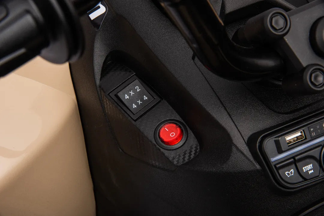 Close-up of 4x2 and 4x4 drive mode switch and red power button on black panel of 24V Can-Am Renegade ATV bike