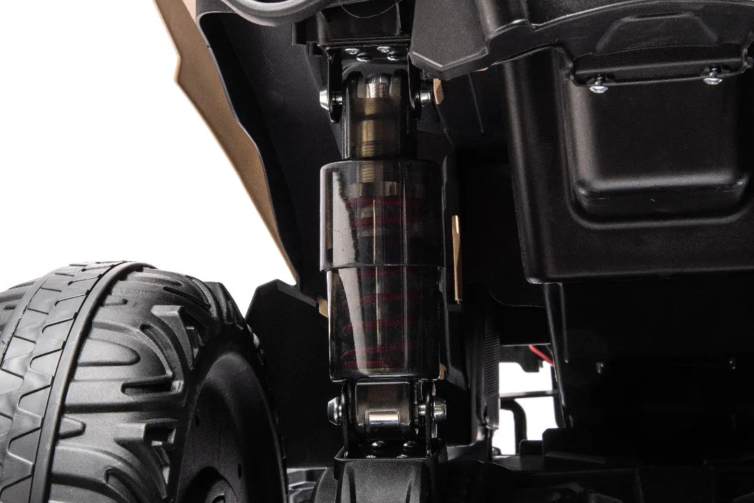 Close-up of rear suspension and rugged tire on khaki 24V 800W licensed Can-Am Renegade 4x4 ATV quad bike for kids