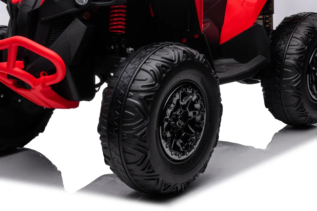 Close-up of black rugged front wheel and suspension of red 24V licensed Can-Am Renegade ride-on ATV quad bike
