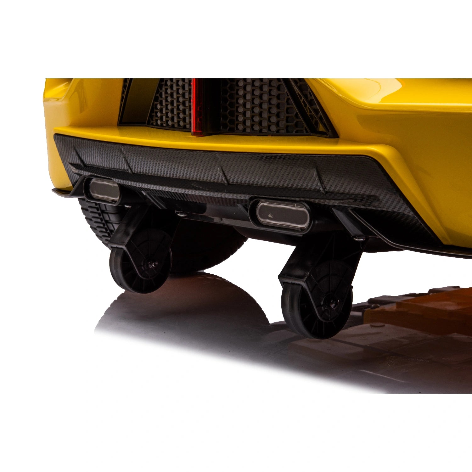 Close-up of rear diffuser and black anti-tip wheels on yellow 12V Lamborghini inspired kids ride-on electric car.