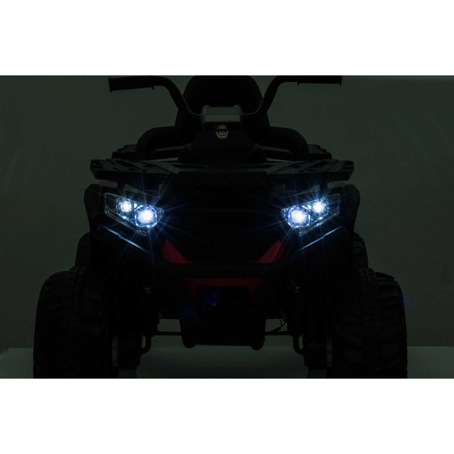 Front view of red 12V kids quad bike ride-on ATV with bright LED headlights and rugged black wheels