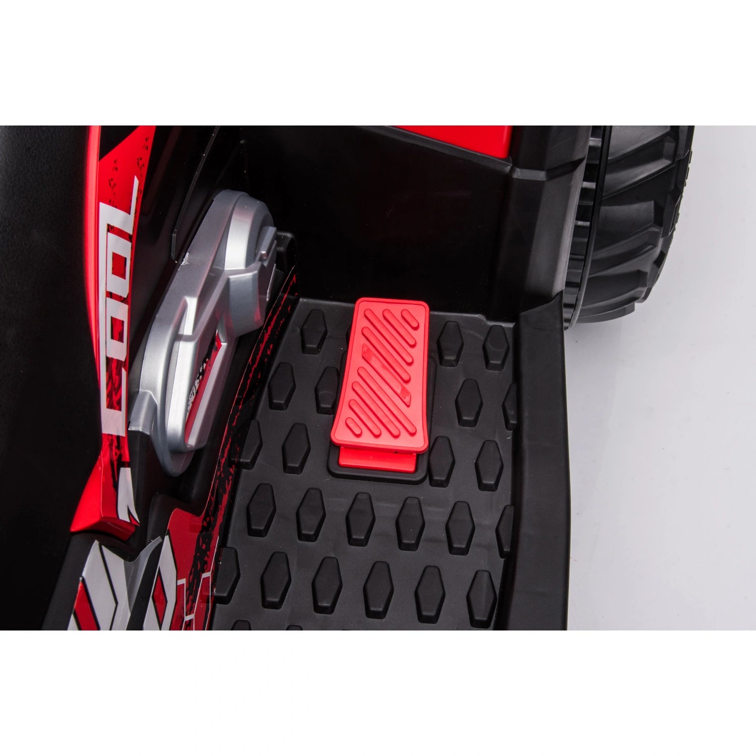 Close-up of red foot pedal and textured black floorboard on red 12V kids quad bike ride-on ATV with 4WD motors