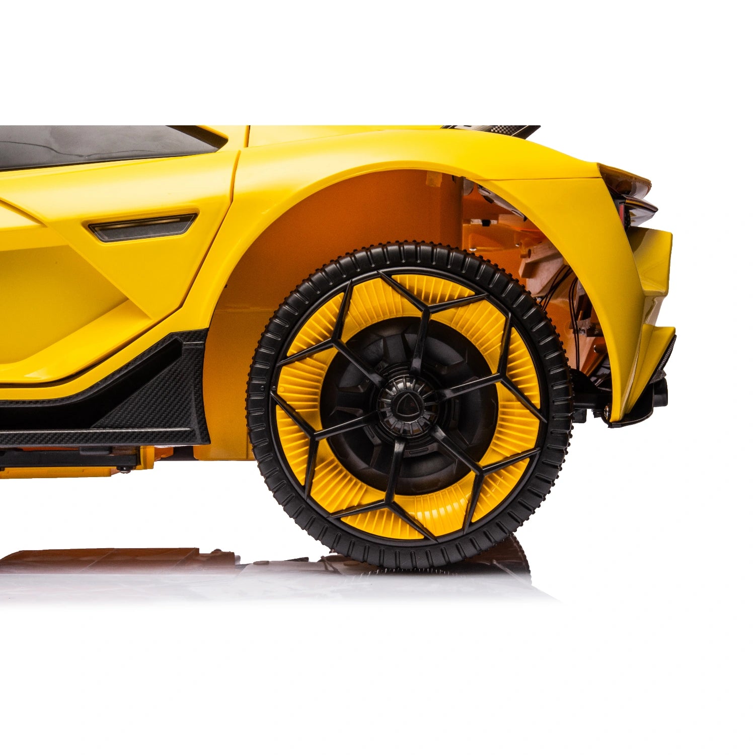 Close-up of rear yellow wheel and tire of 12V Lamborghini inspired kids ride-on electric car with black spokes and aerodynamic design