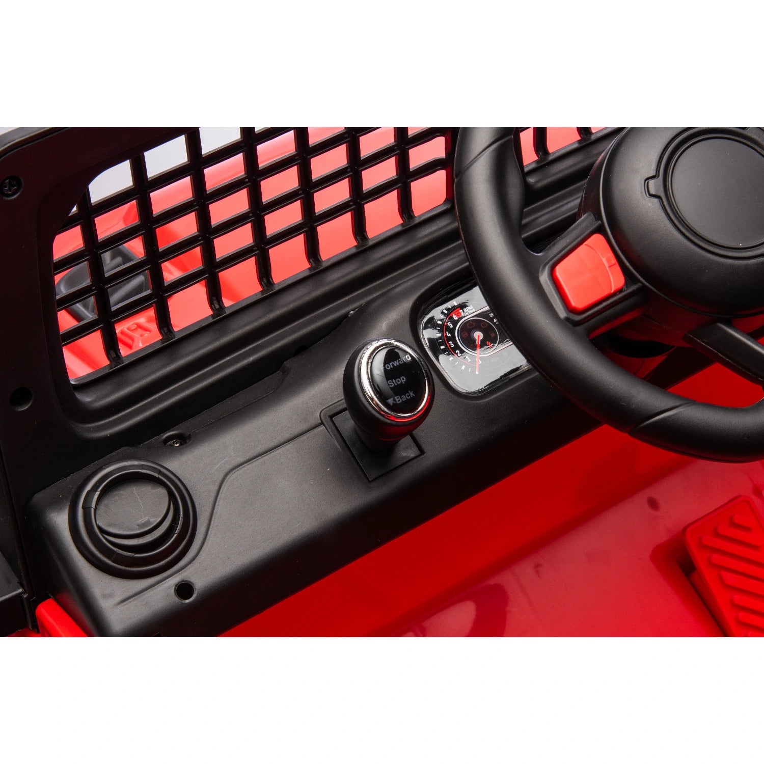 Close-up of black dashboard and steering wheel with ignition key on red 12V off-road electric Jeep ride-on car for kids.