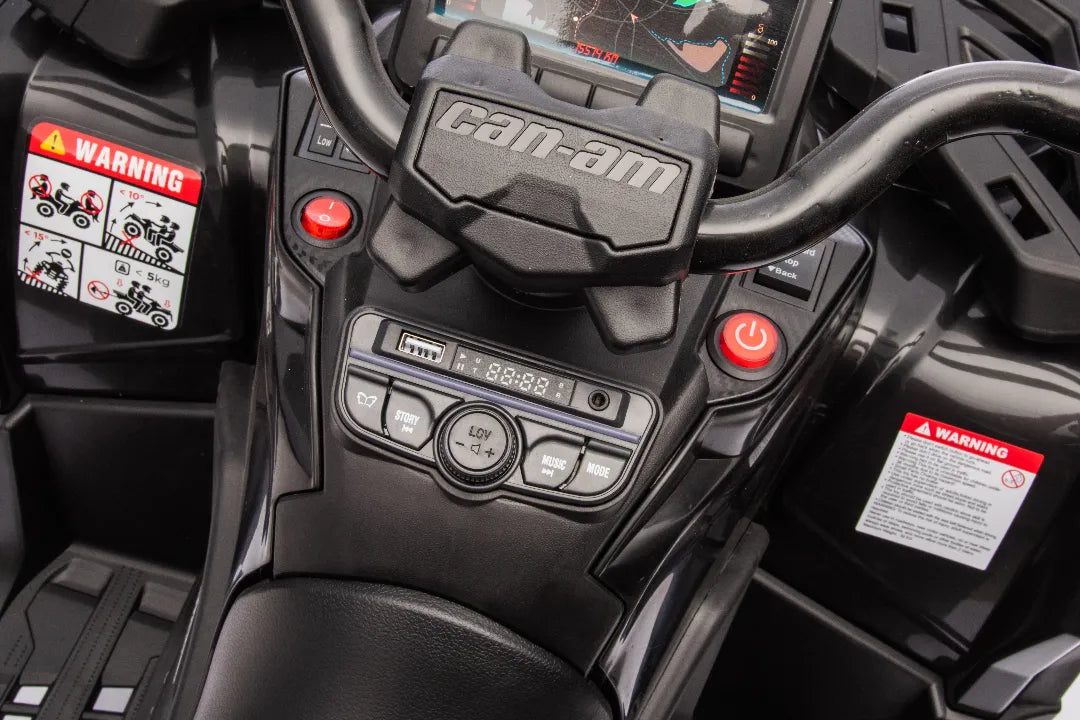 Close-up of black 24V Can-Am Outlander 2-seater ATV dashboard with control buttons and warning labels visible