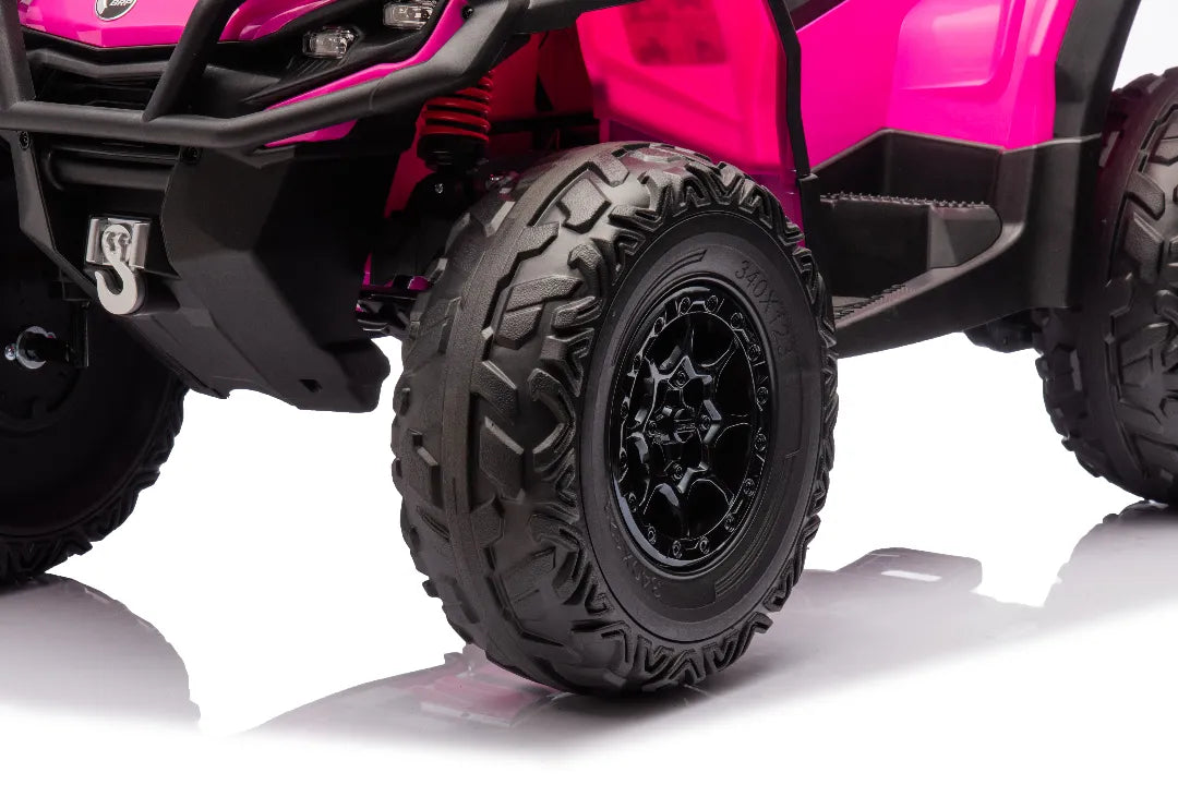 Close-up of front black rugged tire and wheel on pink 24V licensed Can-Am Outlander Monster 2-seater ride-on quad ATV