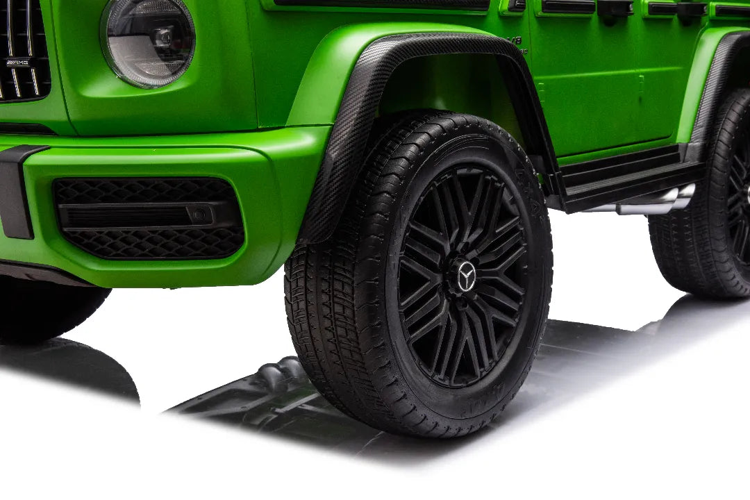 Close-up of front wheel with Mercedes AMG logo on black rim of green 24V 14Ah kids ride-on car G63 model