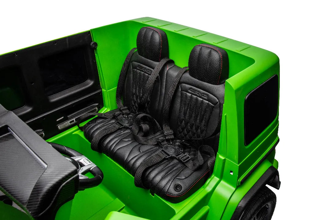 Close-up of black leather seats with red stitching and seat belts in green 24V Mercedes-AMG G63 kids ride-on car