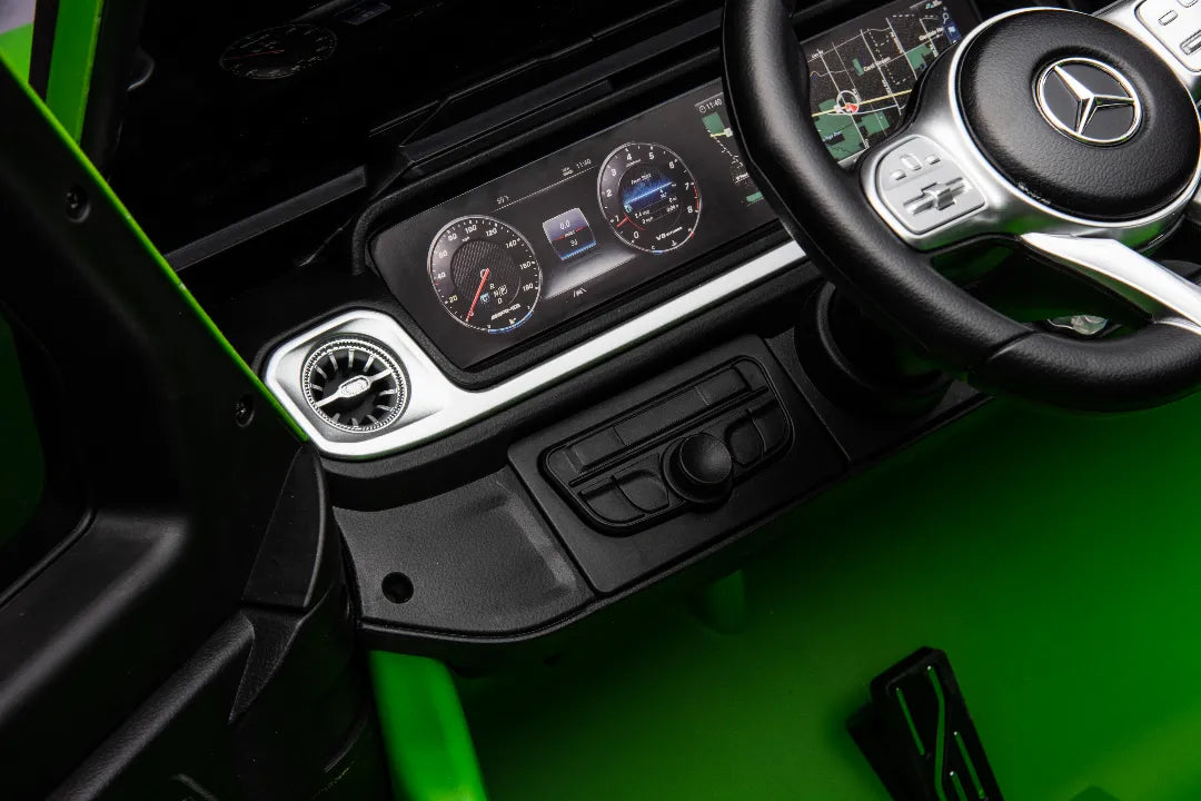 Close-up of dashboard and steering wheel of green 24V Mercedes-AMG G63 kids ride-on car with digital display and control buttons.