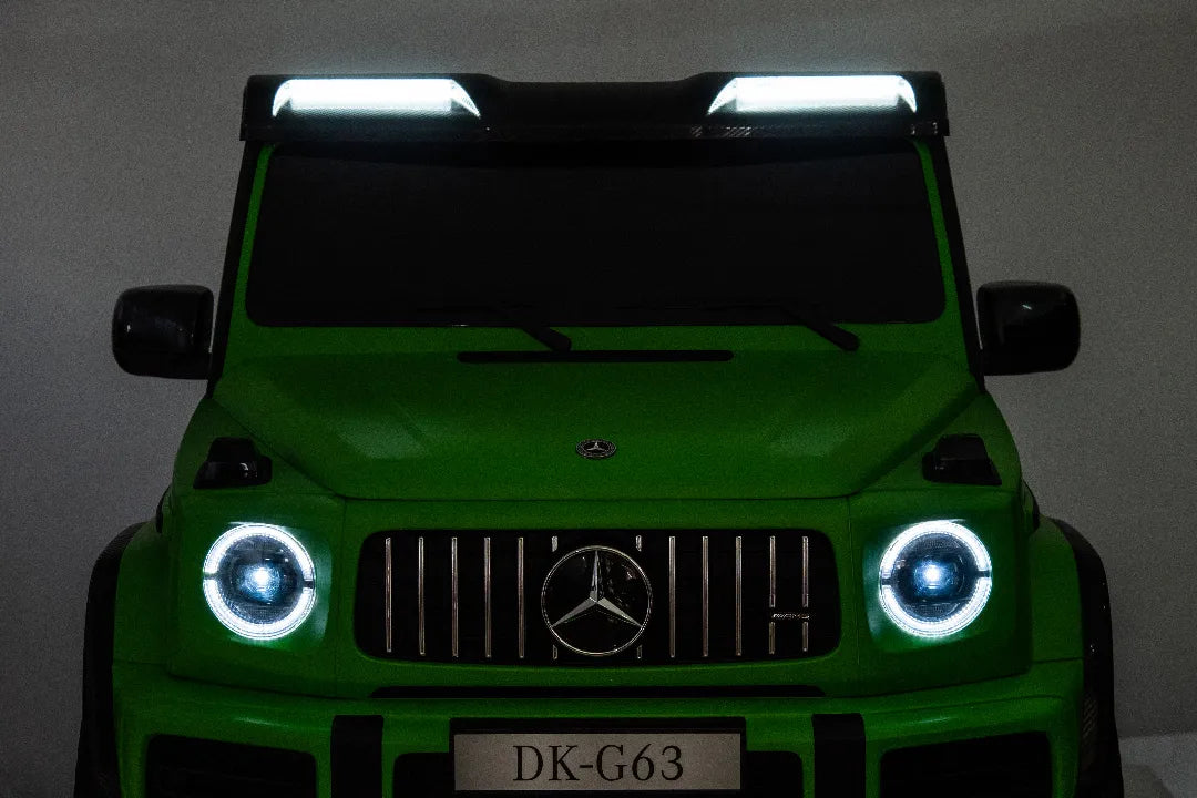 Front view of green 24V licensed Mercedes-AMG G63 kids ride-on car with illuminated LED headlights and roof lights