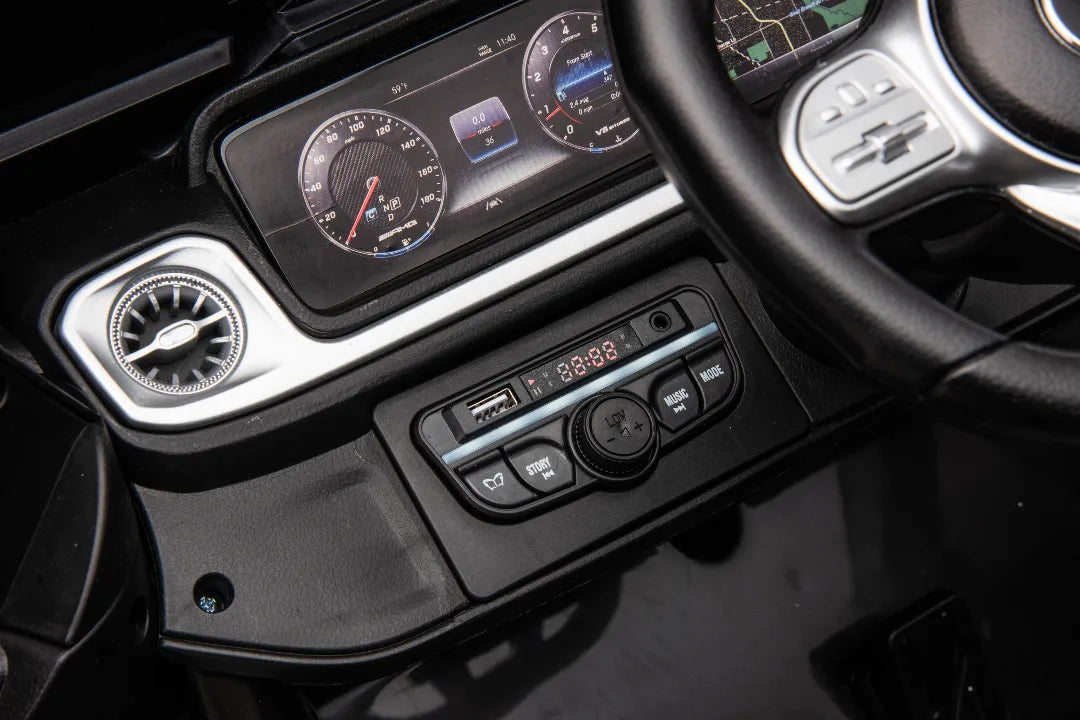 Close-up of dashboard controls and digital speedometer display in black 24V Mercedes-AMG G63 kids ride-on car