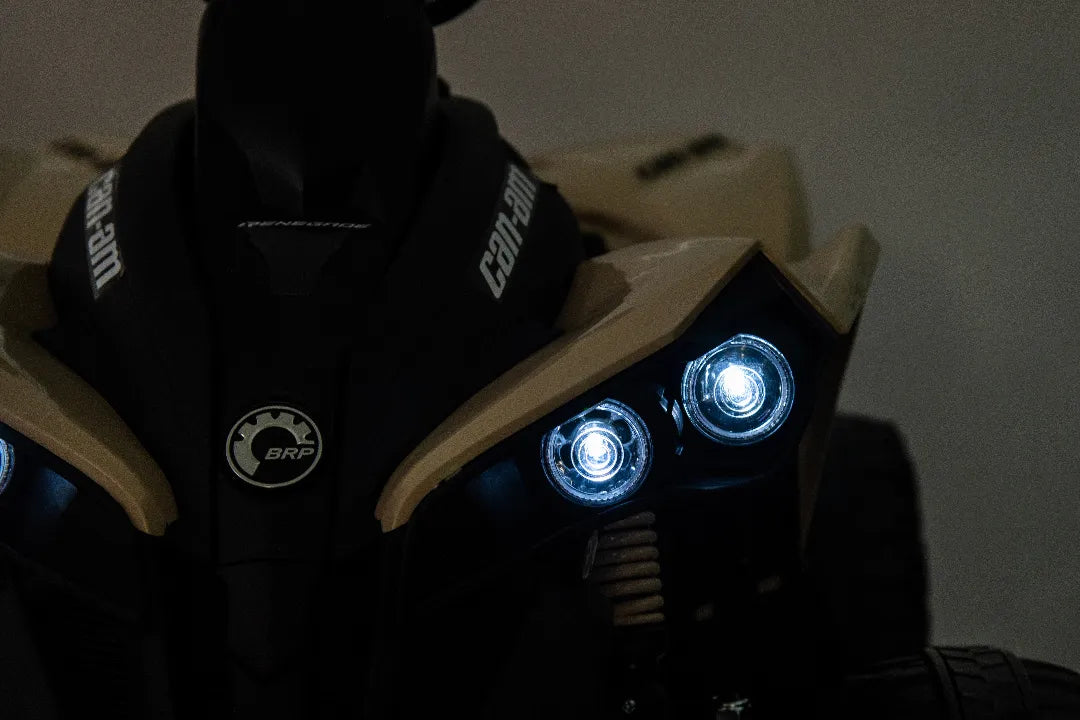 Close-up of illuminated headlights on khaki 24V 800W licensed Can-Am Renegade 4x4 ATV quad bike for kids