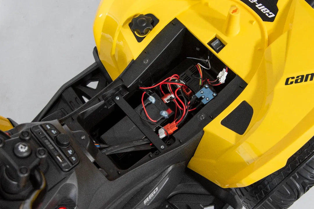 Internal battery compartment and wiring of yellow 24V Can-Am Renegade ride-on ATV quad bike 4x4