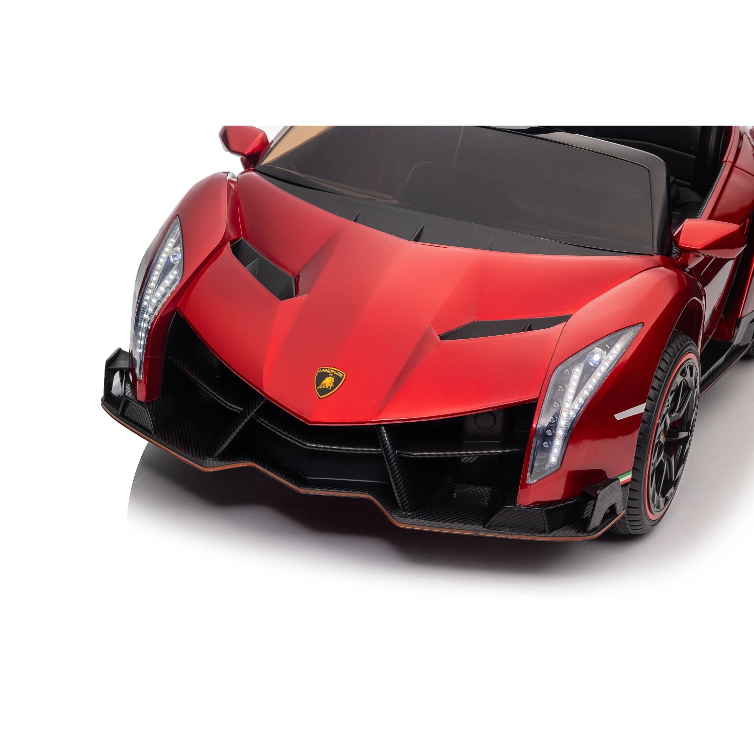 Close-up of red licensed Lamborghini Veneno ride-on car front with detailed headlights and sleek aerodynamic design